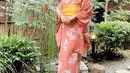 Berpose di pekarangan rumah, Natasha Wilona ini tampil anggun pakai kimono peach dan obi kuning. [@natashawilona12].