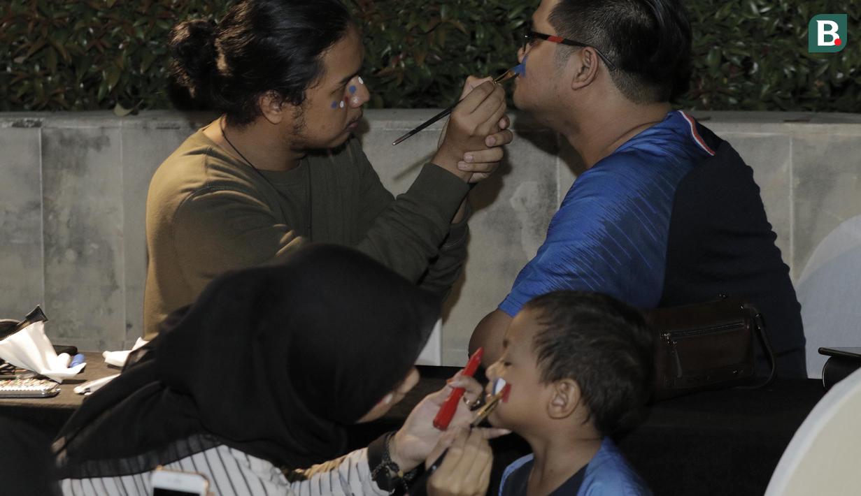 Pengunjung menghias wajahnya dengan gambar bendera saat nobar final Piala Dunia di Hotel Novotel, Tangerang, Minggu, (15/6/2018). Prancis menjadi juara Piala Dunia 2018 usai mengalahkan Kroasia 4-2. (Bola.com/M Iqbal Ichsan)