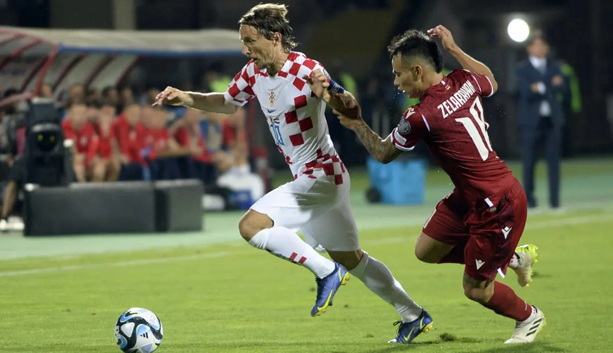 Pemain Kroasia Luka Modric (kiri) berebut bola dengan pemain Armenia Lucas Zelarayan pada pertandingan sepak bola Kualifikasi Euro 2024 di Stadion Republik Vazgen Sargsyan, Yerevan, Armenia, Senin (11/9/2023). (KAREN MINASYAN/AFP)