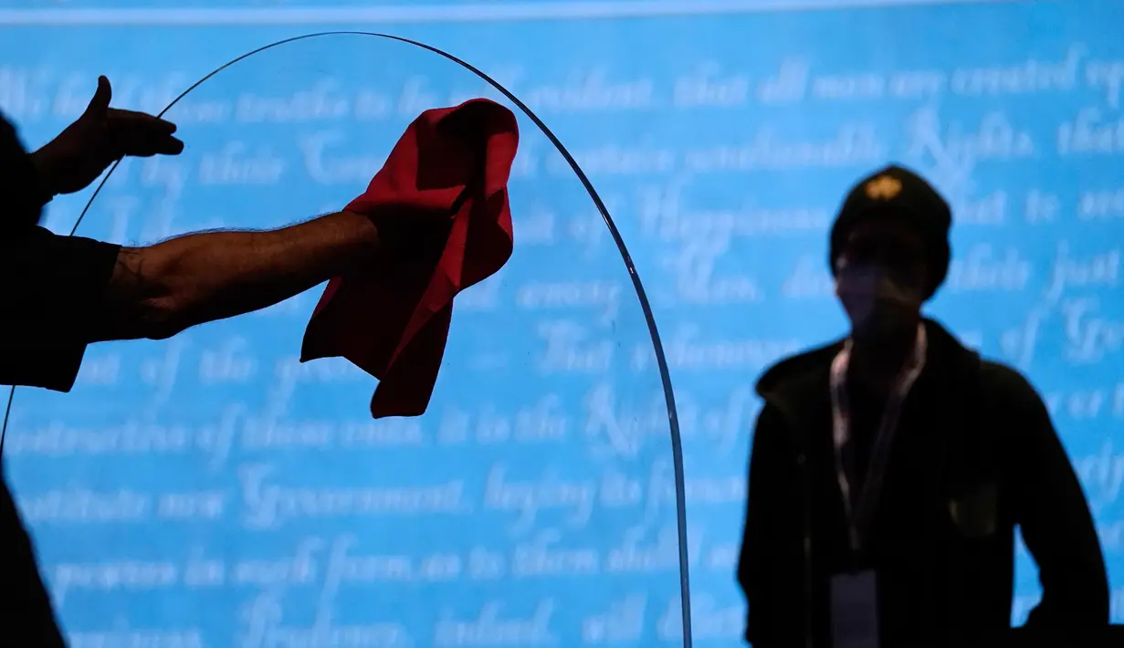 Tim produksi membersihkan panel plastik pelindung di atas panggung di antara meja untuk Wakil Presiden Mike Pence dan penantangnya, Kamala Harris, saat persiapan untuk debat cawapres di Universitas Utah, Salt Lake City, Selasa (6/10/2020). (AP Photo/Julio Cortez)