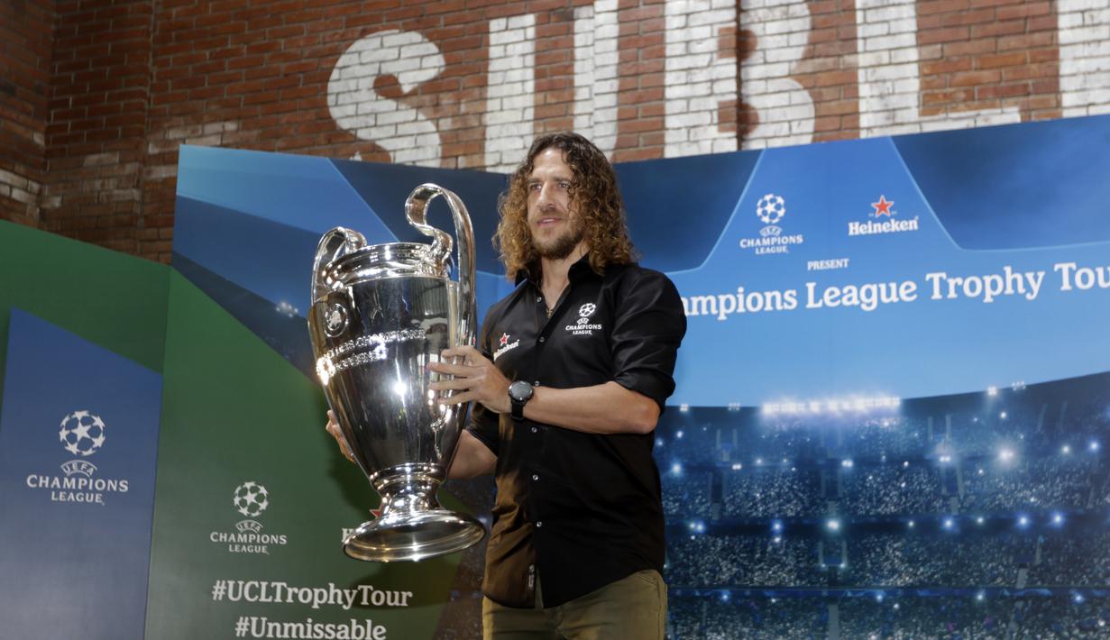 Legenda Barcelona, Carles Puyol, mengangkat trofi Liga Champions saat jumpa pers di Jakarta, Senin (11/3). Heineken memulai perhelatan UEFA Champions League Trophy Tour di Indonesia. (Bola.com/Vitalis Yogi Trisna)