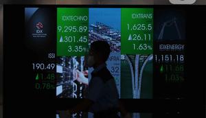 Pekerja melintas di depan layar Indeks Harga Saham Gabungan (IHSG) di BEI, Jakarta, Senin (3/1/2022). Pada pembukan perdagagangan bursa saham 2022 Indeks Harga Saham Gabungan (IHSG) langsung menguat 7,0 poin atau 0,11% di level Rp6.588,57. (Liputan6.com/Angga Yuniar)