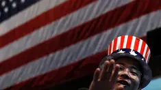 Seorang pria mengenakan topi bermotif bendera Amerika Serikat saat menonton siaran langsung pemilihan presiden AS yang digelar di Kedutaan Besar AS di Beijing, Rabu (9/11). (AP Photo / Andy Wong)