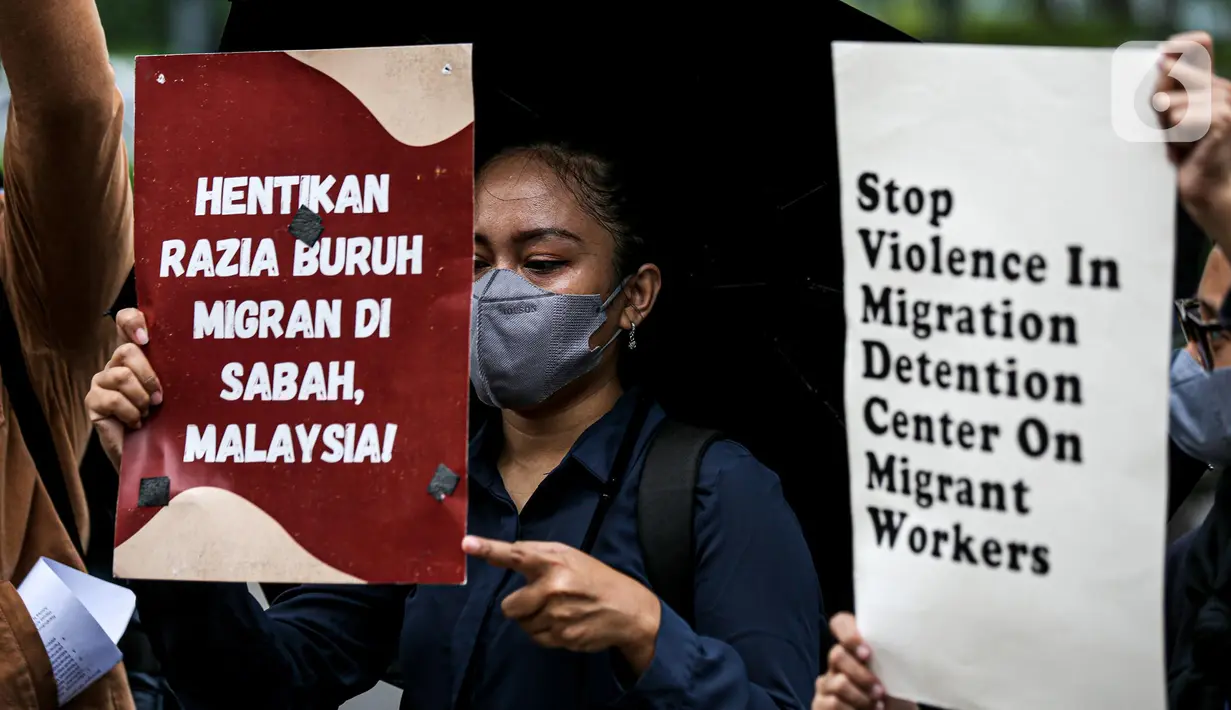 Sejumlah buruh migran membawa poster saat menggelar aksi di depan Kedutaan Besar Malaysia di Jakarta, Selasa (9/8/2022). Mereka menuntut pemerintah Malaysia melakukan perbaikan dan menghentikan berbagai praktik kejam di dalam pusat tahanan imigrasi. (Liputan6.com/Faizal Fanani)