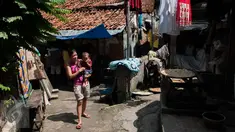 Pejalan kaki melintasi gang menuju rumah yang pernah ditempati Siti Aisyah, WNI yang diduga terlibat pembunuh Kim Jong-nam, kakak tiri pemimpin Korea Utara Kim Jong-un, di Gang Kacang, Kelurahan Angke, Jakarta, Jumat (17/2). (Liputan6.com/Gempur M Surya)