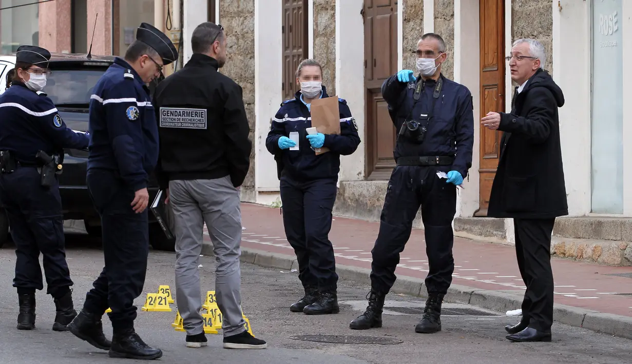 Jaksa Prancis Eric Bouillard (kanan) melakukan penyelidikan di dekat toko daging halal yang diberondong peluru di Propriano di pulau Corsica, Rabu (3/2). Tembakan membuat kaca toko milik warga muslim itu mengalami kerusakan (PASCAL POCHARD-CASABIANCA/AFP)