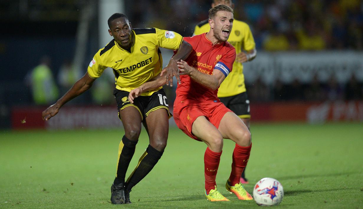 Pemain Burton Albion, Lucas Akins (kiri) menghadang pemain Liverpool, Jordan Henderson pada putaran kedua piala Liga Inggris di Pirelli Stadium, Burton-on-Trent, (24/8/2016) dini hari WIB.  (AFP/Oli Scarf)