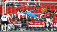 Kiper Manchester United, David de Gea, berusaha menghalau bola saat melawan Fulham pada laga Liga Inggris di Stadion Old Trafford (19/3/2023). (AFP/Paul Ellis)