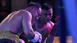 Ilham Leoisa (kanan) mendaratkan pukulan di wajah petinju Thailand, Paiboon Lorkham pada laga kelas Super-Lightweight Mahkota Boxing Super Series di Cilandak Town Square, Jakarta (10/3/2018). Ilham menang angka mutlak. (Bola.com/Nick Hanoatubun)