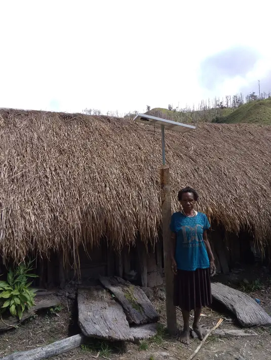Warga berpose di smaping Lampu Tenaga Surya Hemat Energi (LTSHE) yang terpasang di desa terpencil Papua. Pada 2017 Kementrian ESDM telah membagikan paket LTSHE untuk 79.564 rumah di 1.027 desa. (Liputan6.com/HO/Hadi M Djuraid)
