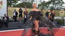 Florence Pugh berpose untuk fotografer setibanya di pemutaran perdana film 'Don't Worry Darling' selama Venice Film Festival 2022 ke-79 di Venesia, Italia (5/9/2022). Berasal dari koleksi Haute Couture Fall/Winter 2022-23, Florence memadukan off-shoulder puss sleeve one-piece dengan rok maxi tulle glitter hitam yang dibordir dengan payet perak.  (Photo by Vianney Le Caer/Invision/AP)