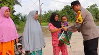 Kapolres Rokan Hilir AKBP Isa Imam Syahroni memberikan bantuan kepada ibu rumah tangga. (Liputan6.com/M Syukur)