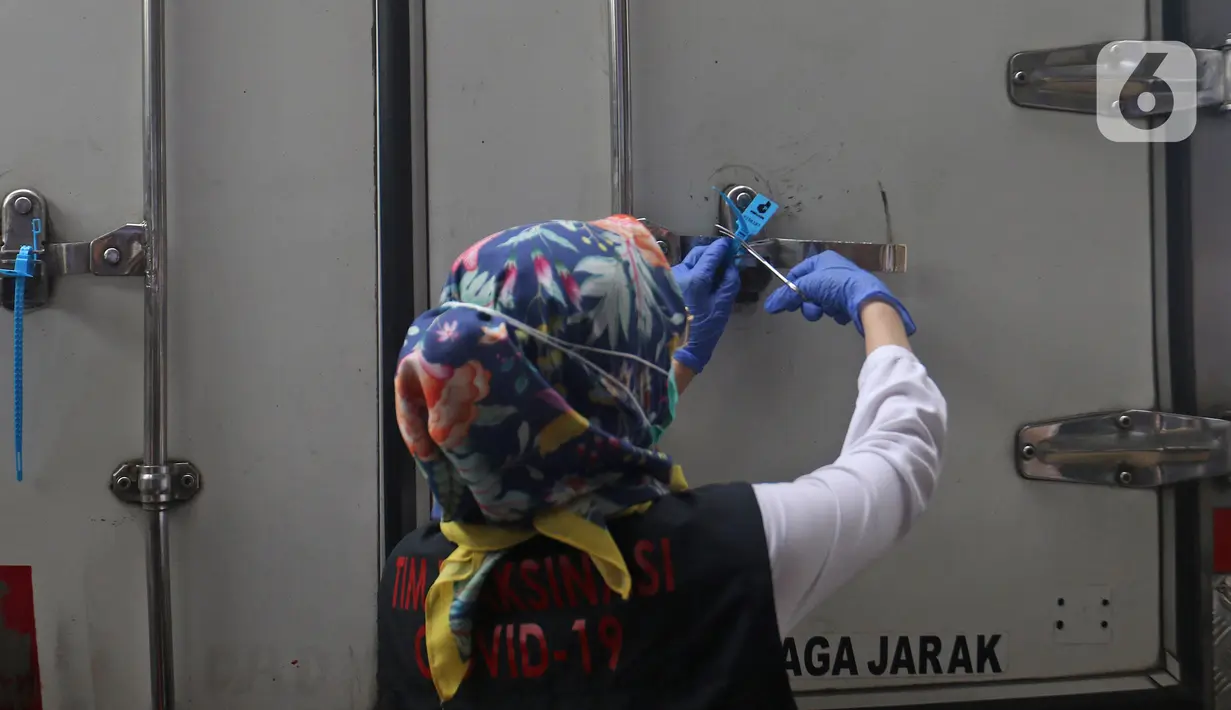 Petugas Dinas Kesehatan Kabupaten Bekasi membuka segel pintu mobil yang membawa kotak berisi vaksin Covid-19 Sinovac setibanya di Gudang UPTD Farmasi, Tambun, Rabu (27/1/2021). Sebanyak 12.000 dosis vaksin COVID-19 dari Biofarma Bandung tiba di Kabupaten Bekasi. (Liputan6.com/Herman Zakharia)