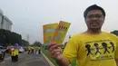 Seorang aktivis menunjukkan brosur mengenai kanker dalam aksi damai di Jalan Bundaran Tugu Tani, Jakarta, Rabu (4/2/2015). (Liputan6.com/Herman Zakharia) 