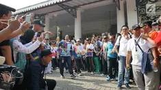 Gubernur DKI, Anies Baswedan membawa obor saat Pawai Obor Asian Para Games di Balai Kota DKI Jakarta, Minggu (30/9). Pawai obor dimulai dari Balai Kota dan berakhir di Gedung Kementerian Pemuda dan Olahraga (Kemenpora). (Liputan6.com/Herman Zakahria)