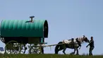 Anggota komunitas saat menarik kudanya yang dipasang karavan untuk mengikuti kegiatan tradisional selama Horse Fair di Westmorland , Inggris utara , 2 Juni 2016. Sejumlah penunggang atau penyuka kuda mengikuti acara ini. (REUTERS / Phil Noble)