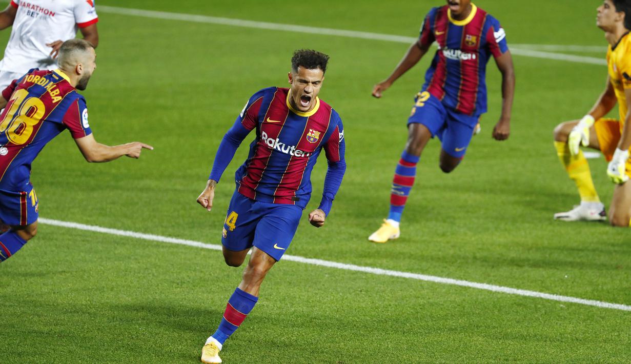 Penyerang Barcelona, Philippe Coutinho, melakukan selebrasi usai mencetak gol ke gawang Sevilla pada laga Liga Spanyol di Stadion Camp Nou, Minggu (4/10/2020). Kedua tim bermain imbang 1-1. (AP Photo/Joan Monfort)