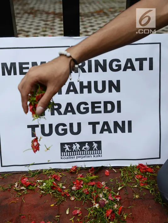 Aktivis Koalisi Pejalan Kaki tabur bunga untuk memperingati Hari Pejalan Kaki Nasional di kawasan Tugu Tani, Jakarta, Selasa, (22/1). Rasio kecelakaan lalu lintas mencapai lebih dari 12 orang per 100.000 penduduk. (Merdeka.com/Imam Buhori)