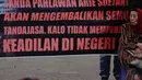 Janda veteran, Ibu Arie Soetanto menggelar aksi untuk mengembalikan tujuh tanda jasa kepahlawanan suaminya, Arie Soetanto (eks TNI Brigade XVII Tentara Pelajar) kepada negara melalui Presiden Jokowi di depan Istana Negara, Jakarta, Selasa (9/12/2014). (Li
