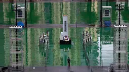 Seorang pria berjalan melewati replika Monumen Pahlawan Rakyat yang dipajang di Taman Victoria Hong Kong (4/6/2019). Puluhan ribu orang diperkirakan akan menghadiri acara nyala lilin tahunan untuk para korban tragedi Tiananmen 1989. (AP Photo/Vincent Yu)
