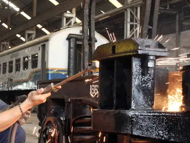 Seorang pekerja menyelesaikan perbaikan gerbong kereta api di Balai Yasa, Manggarai, Jakarta, Rabu (1/7/2015). PT KAI menyiapkan 30 perjalanan kereta api tambahan untuk mengangkut para pemudik jelang Lebaran. (Liputan6.com/Helmi Afandi)