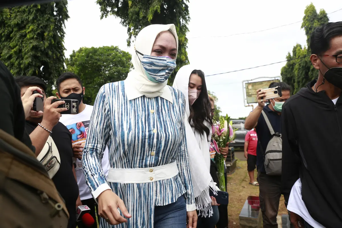 Angelina Sondakh ziarah ke makam suaminya Adjie Massaid usai bebas dari penjara. Angie ditemani anak-anaknya. (Kapanlagi.com/Akrom Sukarya)