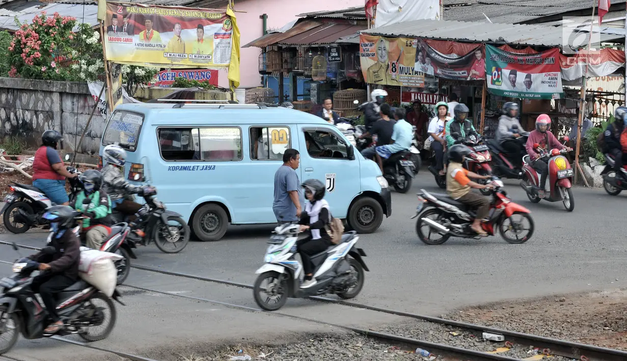 Sejumlah kendaraan melintasi perlintasan kereta api Nomor 52 di Pisangan Lama, Jakarta, Kamis (11/4). Pintu perlintasan ini dan JPL 66 di Jalan Stasiun Cakung akan ditutup permanen saat diberlakukannya Double Double Track (DDT) lintas Manggarai-Cikarang. (merdeka.com/Iqbal S. Nugroho)