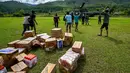 BNPB juga telah mengerahkan empat helikopter untuk mendistribusikan bantuan ke empat kabupaten tersebut. Tampak dalam foto, warga membawa bantuan yang didistribusikan oleh personel TNI AU di wilayah terdampak banjir di Kabupaten Bener Meriah, Provinsi Aceh, pada Kamis 4 Desember 2025. (CHAIDEER MAHYUDDIN/AFP)