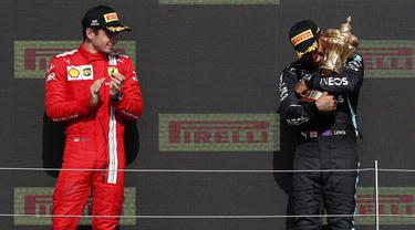 Pembalap Mercedes, Lewis Hamilton (kanan) berhasil meraih podium juara F1 GP Inggris, Minggu (18/7/2021) malam WIB. Sedangkan pembalap Ferrari Charles Leclerc menempati posisi kedua dalam balapan tersebut. (Foto: AFP/Adrian Dennis)
