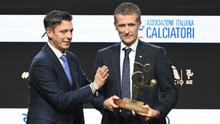 Wasit Italia, Daniele Orsato, berpose di atas panggung setelah menerima penghargaan 'Wasit Terbaik' dari Gianluca Rocchi (kiri) selama acara penghargaan Italian Footballers' Association (AIC) 2023 pada 4 Desember 2023 di Milan. (Marco BERTORELLO/AFP)
