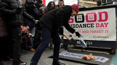 Seorang wanita melemparkan barang miliknya untuk dihancurkan dalam acara "Good Riddance Day" di Times Square, New York, Rabu (28/12). Good Riddance Day menjadi tradisi warga New York menghapus kenangan buruk selama satu tahun. (REUTERS/Darren Ornitz)