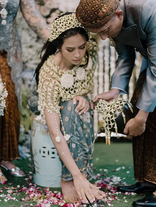 Prosesi siraman Maudy Ayunda juga menarik untuk disimak. Tampil menawan dalam balutan ronce melati di kepala dan tubuh bagian atasnya, Maudy memadukan penampilannya dengan kain batik biru kehijauan sebagai rok. Foto: Instagram.