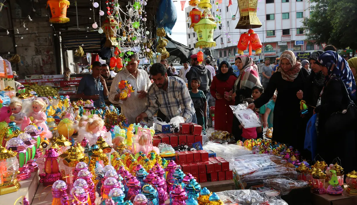 Para calon pembeli memilih lentera Ramadan yang dijajakan salah satu kios di pasar Kota Gaza, Kamis (25/5). Warga Palestina merayakan datangnya bulan puasa dengan memasang lentera tradisional khas Ramadan sebagai dekorasi rumah. (AP Photo/Adel Hana)