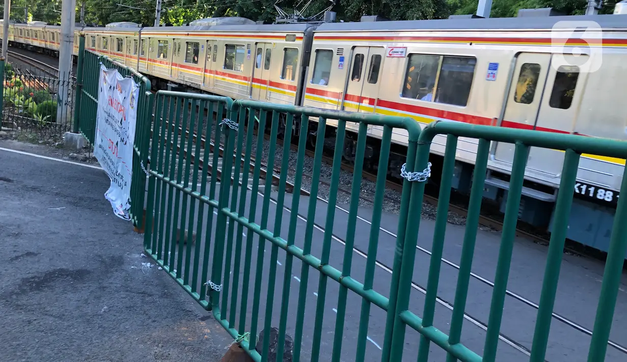 Kereta melintas di perlintasan sebidang dekat Stasiun Palmerah dan Gedung DPR/MPR yang ditutup permanen di Jakarta, Selasa (1/12/2020). Perlintasan ini tengah dilakukan kajian apakah di lokasi itu memungkinkan pembangunan flyover atau underpass. (Liputan6.com/Immanuel Antonius)