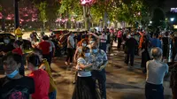 Pasangan mengenakan masker menari di sebuah taman di sebelah Sungai Yangtze, Wuhan, provinsi Hubei tengah China (12/5/2020). China melaporkan tidak ada infeksi virus corona domestik baru pada 12 Mei. (AFP/Hector Retamal)