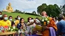 Para biksu Buddha diberi sedekah oleh umat saat mereka memperingati Hari Makha Bucha di kota Narathiwat, Thailand selatan  (6/3/2023). Umat Buddha biasanya pergi ke vihara untuk berbuat kebajikan seperti berderma, bermeditasi, dan mendengarkan dhamma. (AFP/Madaree Tohlala)