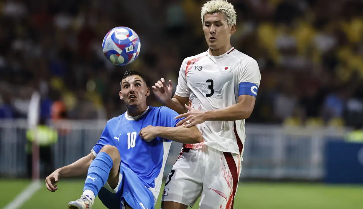 Gelandang Isrel Oscar Gloukh berebut bola dengan bek Jepang Ryuya Nishio pada matchday terakhir Grup D sepak bola Olimpiade Paris 2024 di stadion stade de la Beaujoire, Rabu (31/7/2024). (AP Photo/Jeremias Gonzalez)