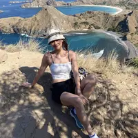 Berlibur ke Pulau Komodo, Gege Elisa tampil dengan spaggeti strap putih untuk atasan dipadukan celana pendek hitam. Ia tampil dengan bukcet hat putihnya. Credit: @gegeelisa94