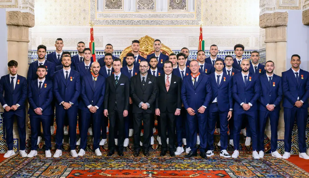 Raja Maroko Mohammed VI (tengah) diapit Putra Mahkota Maroko Moulay El Hassan (kiri) dan Pangeran Moulay Rachid (kanan) berpose bersama pemain Timnas Maroko di Istana, Rabat, Maroko, 20 Desember 2022. Timnas Maroko mendapat sambutan hangat di negaranya setelah berhasil meraih juara keempat Piala Dunia 2022. (Moroccan Royal Palace via AP)