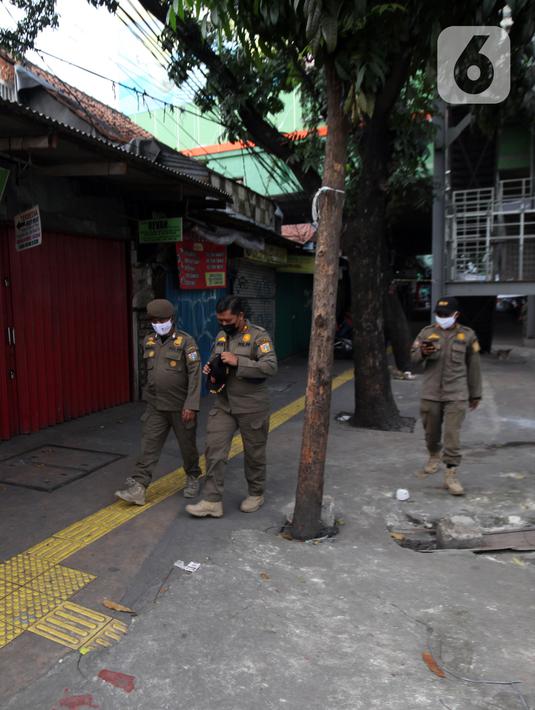 Petugas Satpop PP berpatroli di kawasan Pasar Tanah Abang, Jakarta, Rabu (7/7/2021). Satpol PP melakukan penjagaan di seluruh Pasar Tanah Abang mengantisipasi pedagang yang membandel tetap berjualan saat diberlakukannya PPKM Darurat. (Liputan6.com/Angga Yuniar)