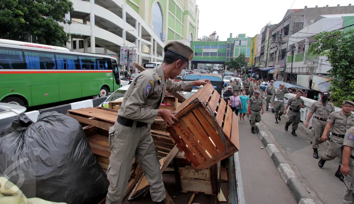 Barang-barang dari PKL diangkut Satpol PP di Pasar Tanah Abang, Jakarta, Kamis (4/5). Penertiban dilakukan agar tidak menggangu fungsi pedestrian untuk pejalan kaki. (Liputan6.com/Johan Tallo)