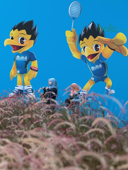 Fans melintas dekat maskot Indonesia Open 2018 di Istora Senayan, Jakarta, (6/7/2018). Indonesia Open 2018 berlangsung dari 3-8 Juli 2018. (Bola.com/Nick Hanoatubun)