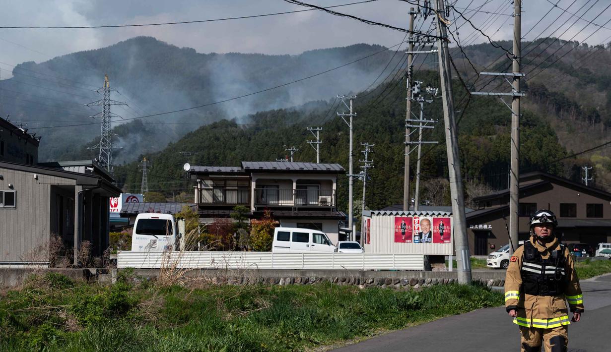 Meski demikian, tidak ada korban jiwa yang dilaporkan. Tampak dalam foto, seorang petugas pemadam kebakaran berjalan di jalan raya sementara asap mengepul di latar belakang kota Otsuchi, Prefektur Iwate, Jepang pada Sabtu 25 April 2026. (ANDREW CABALLERO-REYNOLDS/AFP)