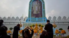 Warga Thailand memberi penghormatan di depan potret mendiang Raja Thailand Bhumibol Adulyadej di luar Grand Palace, Bangkok, Thailand (13/10). Upacara ini untuk memperingati satu tahun wafatnya Raja Bhumibol Adulyadej. (AP Photo/Gemunu Amarasinghe)