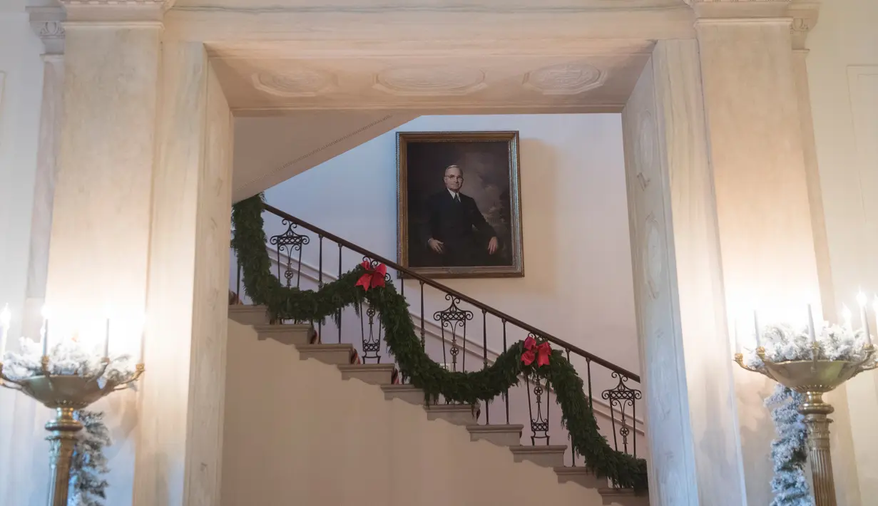 Dekorasi Natal menghiasi tangga di Gedung Putih, Washington DC, Senin (27/11). First Lady Melania Trump mendekorasi perayaan Natal dengan tema 'Time-Honored Traditions' yang mencerminkan tradisi liburan 200 tahun di Gedung Putih. (SAUL LOEB / AFP)