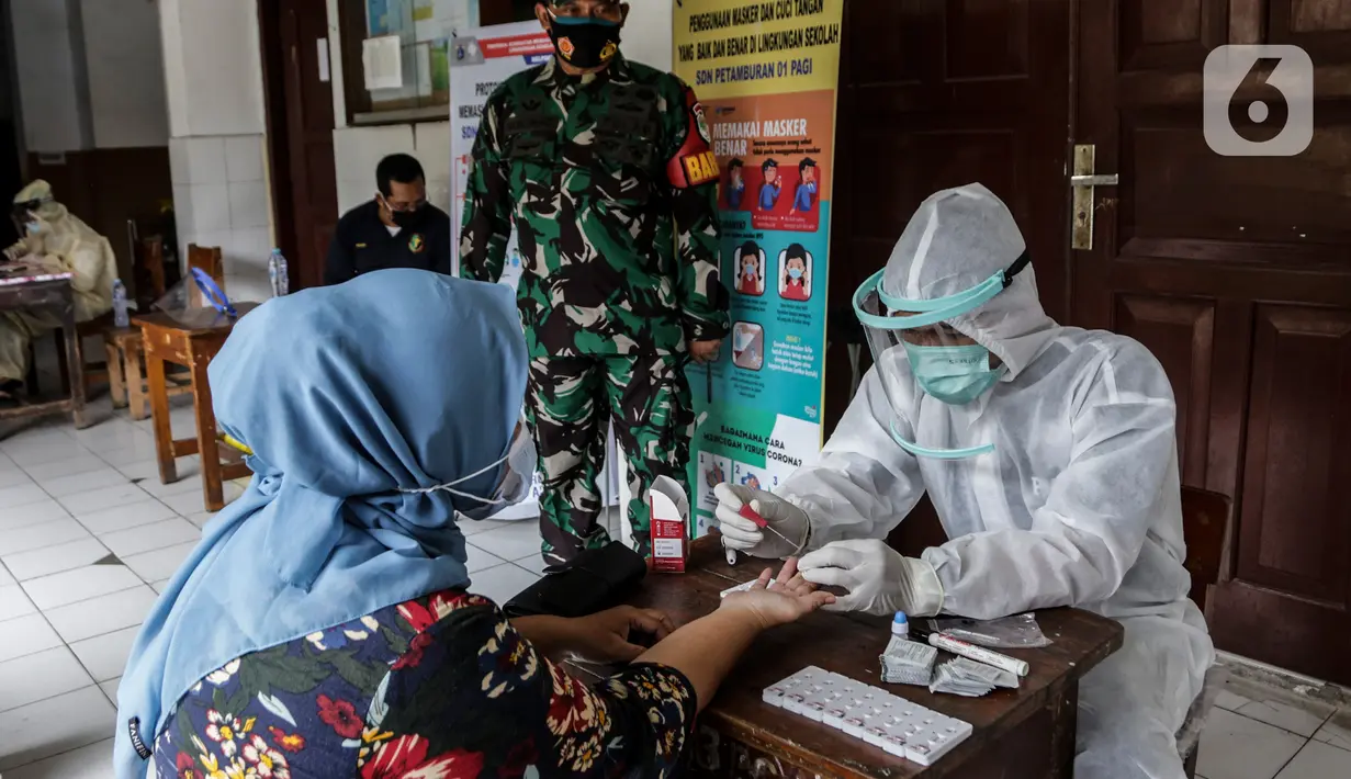 Warga melakukan tes cepat (rapid test) massal Covid-19 di SDN Petamburan 01, Petamburan, Jakakrta, Jumat (27/11/2020). Rapid Test massal tersebut digelar kembali karena sebelumnya masih banyaknya warga yang tidak mau ikut karena merasa takut. (Liputan6.com/Johan Tallo)