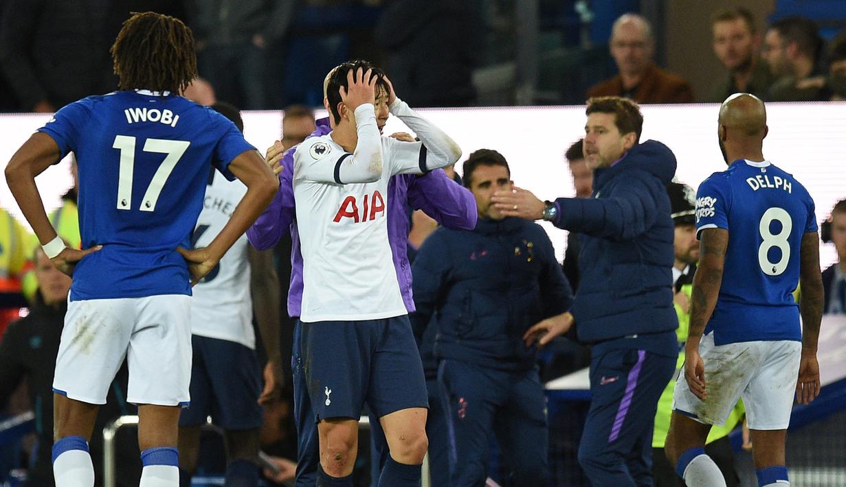 Penyerang Tottenham Hotspur, Son Heung-min, tampak menyesal usai melakukan pelanggaran terhadap gelandang Everton, Andre Gomes, pada laga Premier League di Goodison Park, Minggu (3/11). Tekel tersebut menyebabkan Gomes mengalami patah kaki. (AFP/Oli Scarff)