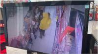 Seorang ibu menggendong bayi saat menjalankan aksi pencurian di sebuah minimarket (Arfandi/Liputan6.com)