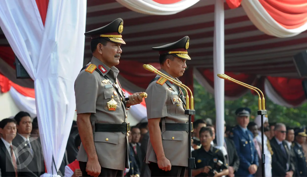 Jenderal Badrodin Haiti dan Jenderal Tito Karnavian berdiri di atas mimbar dalam upacara sertijab Kapolri di Stadion PTIK, Jakarta, Kamis (14/7). Badrodin Haiti resmi menyerahkan tongkat komando Kapolri kepada Tito Karnavian. (Liputan6.com/Helmi Afandi)