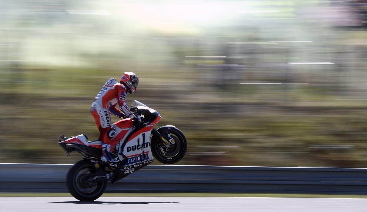 Gaya pebalap Ducati Team, Andrea Dovizioso dengan mengangkat ban pada kualifikasi MotoGp di Sirkuit Brno, (5/8/2017). Marc Marquez menjadi juara pada balapan tersebut. (AFP/Michal Cizek) 